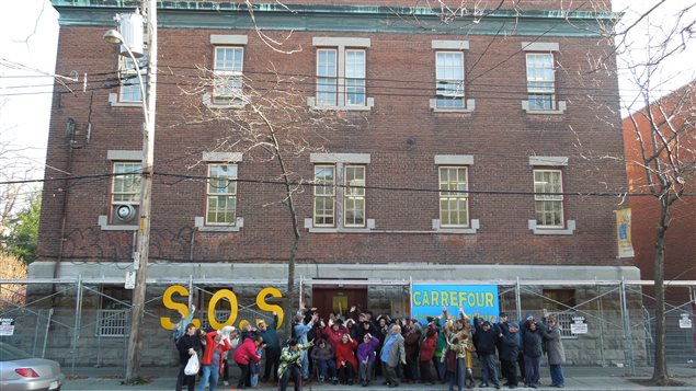 Groupe devant un édifice qui lance un SOS